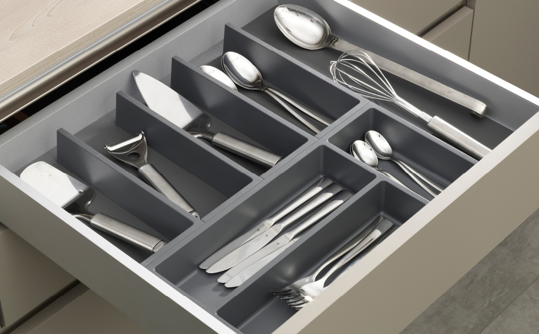 Geöffneter Küchenschubkasten mit grauem Besteck- und Utensilieneinsatz